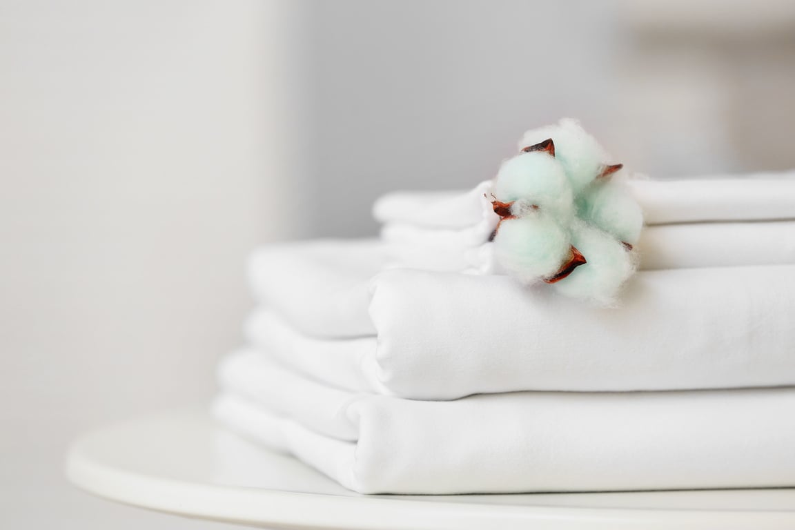 Stack of Clean Bed Sheets on Table